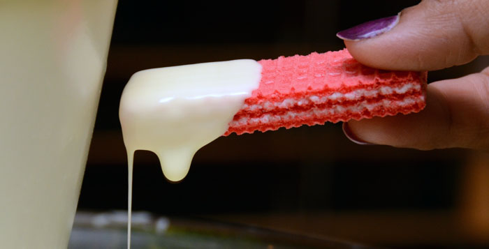 Wafer dipped in white chocolate fountain